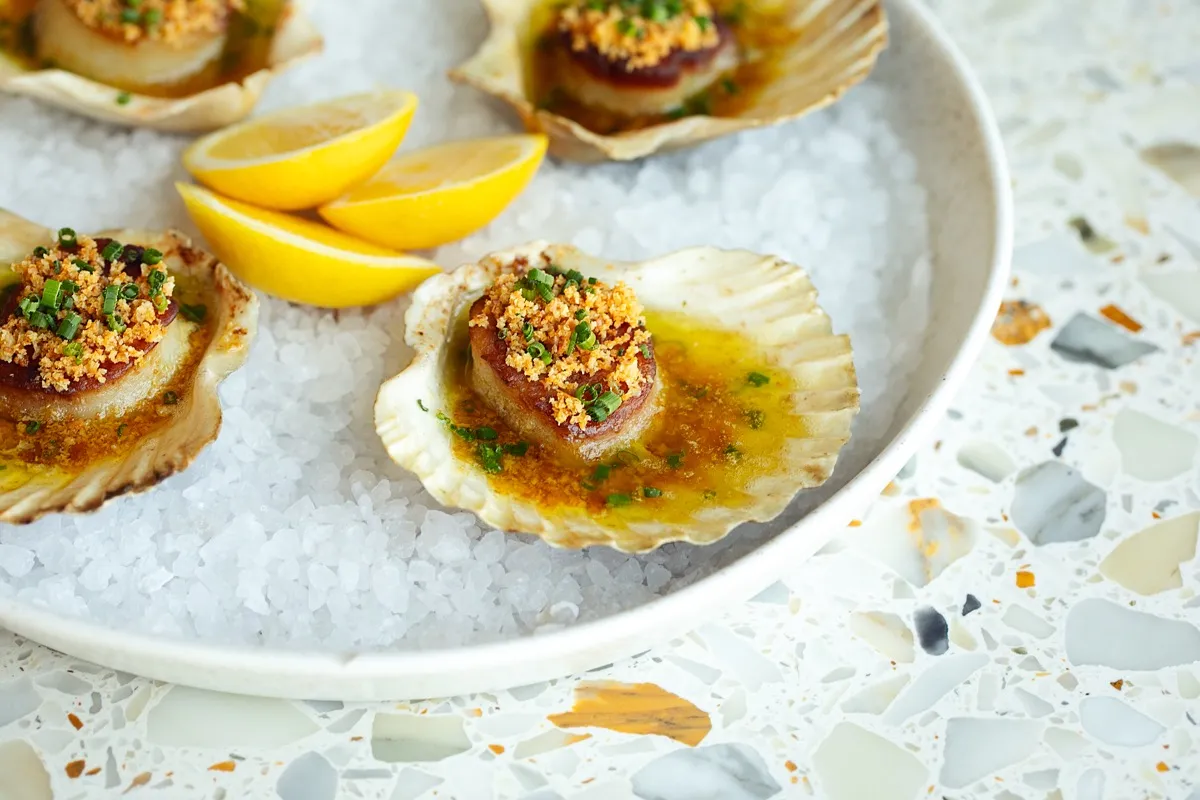 Grilled scallops on the half shell with lemon
